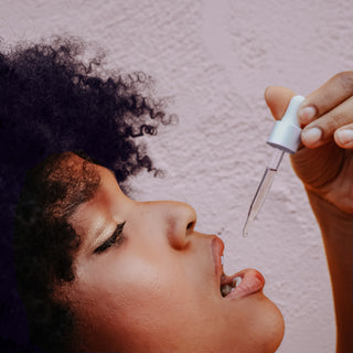 Woman dropping CBD oil tincture into her mouth