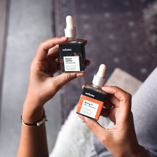 Woman holding a bottle of broad spectrum CBD and adaptogen oil and a bottle of strong broad-spectrum cbd oil
