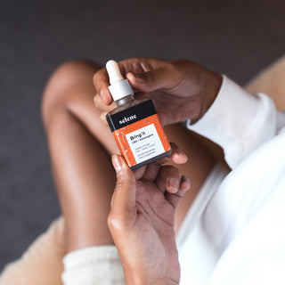 Woman holding bottle of organic cbd and adaptogen oil