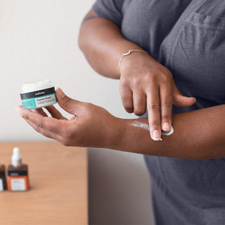 Woman applying CBD cream to forearm to relieve joint and muscle pain