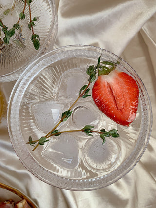 Glass of sparkling water with thyme and strawberry, DIY CBD seltzer