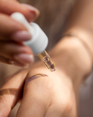 Person using dropper to apply cbd oil to hand