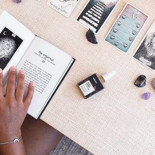 Woman doing a tarot reading, while using broad-spectrum CBD extract