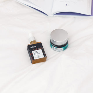 Broad-spectrum CBD oil and CBD cream with active botanicals on a bed